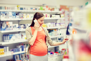 Image showing happy pregnant woman with smartphone at pharmacy