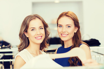 Image showing happy women with shopping bags at clothing shop