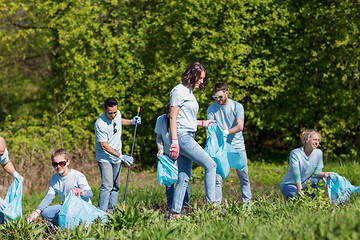 Image showing volunteers with garbage bags cleaning park area