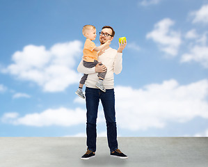 Image showing happy father and little son with green apple