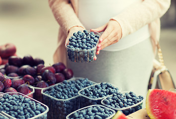 Image showing pregnant woman buying blueberries at street market