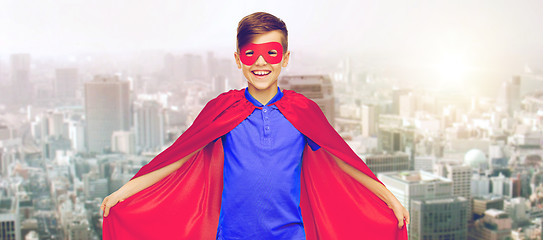 Image showing boy in red superhero cape and mask over city