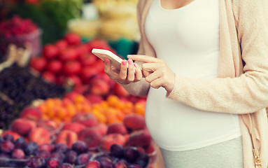 Image showing pregnant woman with smartphone at street market