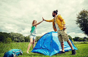 Image showing happy couple setting up tent outdoors