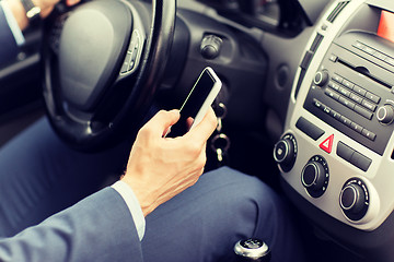 Image showing close up of man hand with smartphone driving car