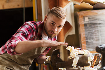 Image showing carpenter working with wood plank at workshop