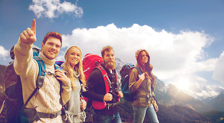 Image showing group of smiling friends with backpacks hiking