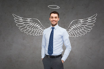 Image showing smiling businessman with angel wings and nimbus