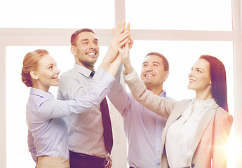 Image showing happy business team giving high five in office