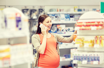 Image showing happy pregnant woman with smartphone at pharmacy