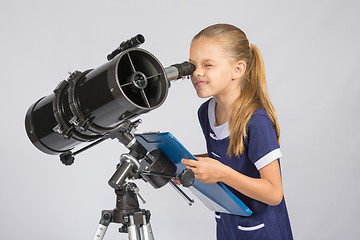 Image showing The young astronomer happy to look through the telescope recording observations