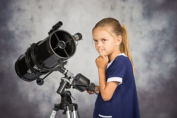 Image showing Seven-year girl looks at the sky while standing at the telescope