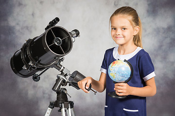 Image showing Seven-year girl is happy with the globe in a reflector telescope