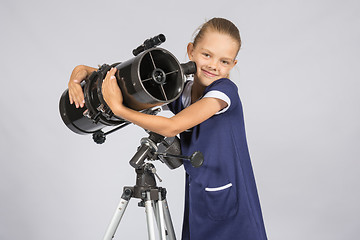 Image showing Seven-year girl hugging her given reflector telescope