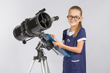 Image showing The young astronomer happy to look through the telescope recording observations