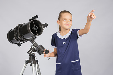 Image showing The young astronomer shows the starry sky while standing at the telescope