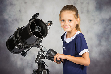 Image showing Seven-year girl adjusts the telescope and looked into the frame