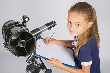 Image showing Young Astronomer writes the results of observations in the document