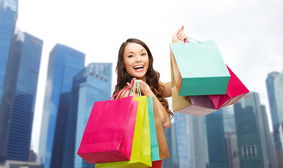 Image showing happy woman with shopping bags over singapore city