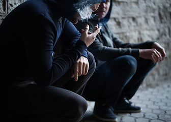 Image showing close up of young men smoking cigarettes