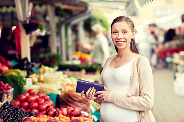 Image showing pregnant woman with wallet buying food at market