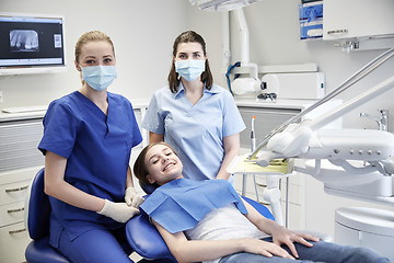 Image showing happy female dentist with patient girl at clinic