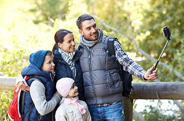 Image showing happy family with smartphone selfie stick in woods