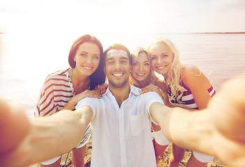 Image showing happy friends on beach and taking selfie