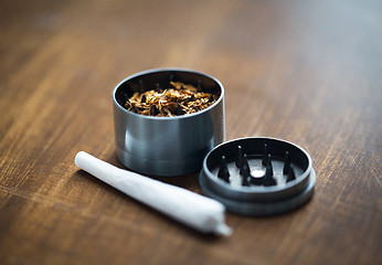Image showing close up of marijuana joint and herb grinder