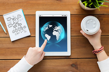 Image showing close up of woman with tablet pc on wooden table