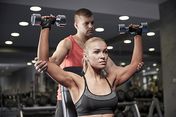 Image showing man and woman with dumbbells in gym