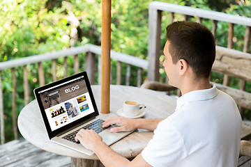 Image showing close up of man with laptop blogging on terrace