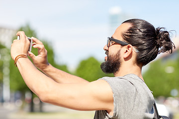 Image showing man taking video or selfie by smartphone in city