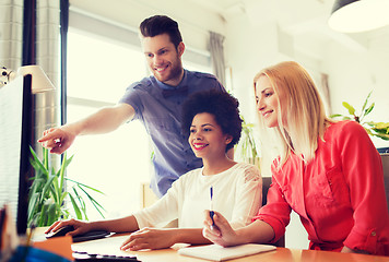 Image showing happy creative team with computer in office