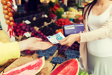 Image showing pregnant woman with wallet buying food at market