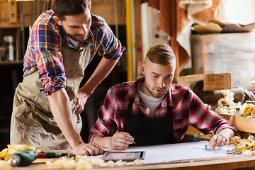 Image showing carpenters with ruler and blueprint at workshop