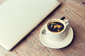 Image showing close up of laptop and coffee cup with world map