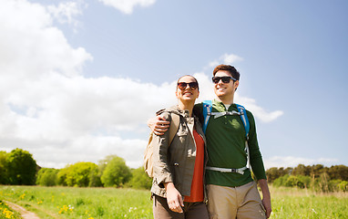 Image showing happy couple with backpacks hiking outdoors