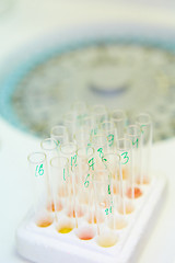 Image showing pipette dropping sample into a test tube,abstract science background