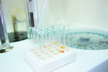 Image showing pipette dropping sample into a test tube,abstract science background