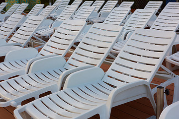 Image showing number of empty sunbeds at the pool early in the morning