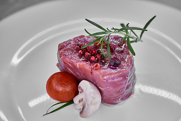 Image showing raw beef meat fillet with peppercorn and thyme ready to grill