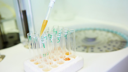 Image showing pipette dropping sample into a test tube,abstract science background