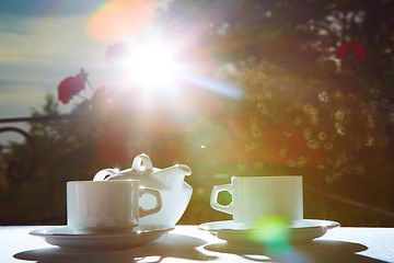 Image showing white teapot, two cups and sun. Garden party.