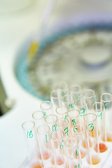 Image showing pipette dropping sample into a test tube,abstract science background