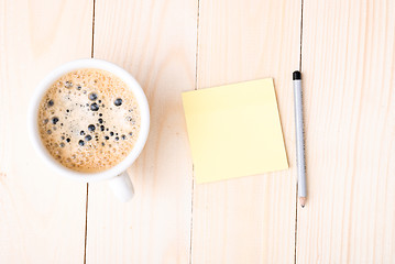 Image showing Wood desk with office supplies and cup of coffee