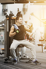 Image showing smiling man exercising on gym machine