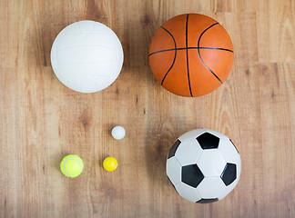 Image showing close up of different sports balls set on wood