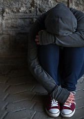 Image showing close up of addict woman hiding her face on street