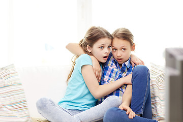 Image showing scared little girls watching horror on tv at home